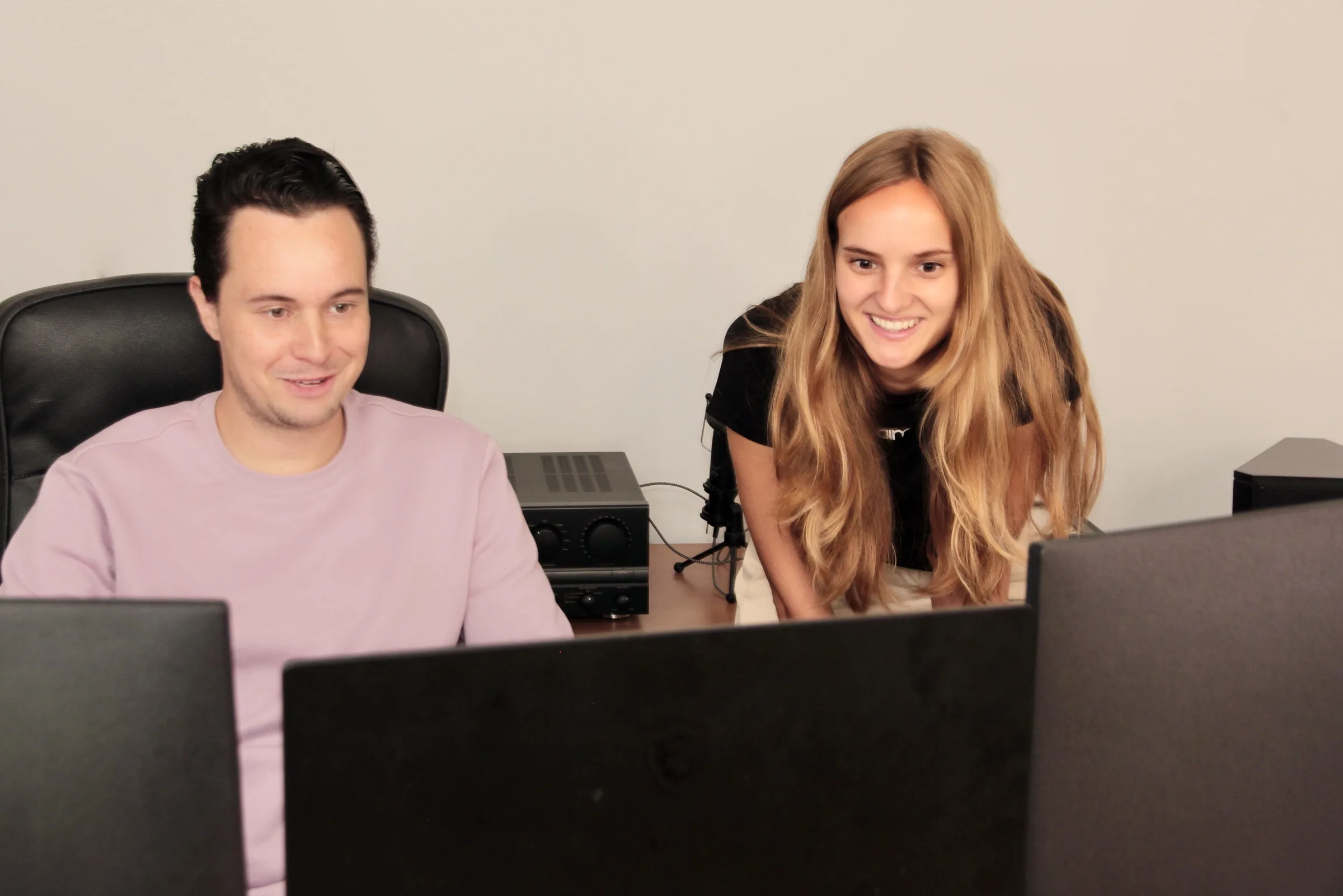 Twee ComfyCoders-collega's werken samen achter de schermen op kantoor