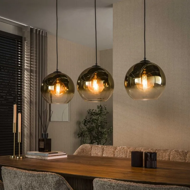 Drie glazen hanglampen van LampenTotaal boven een eettafel